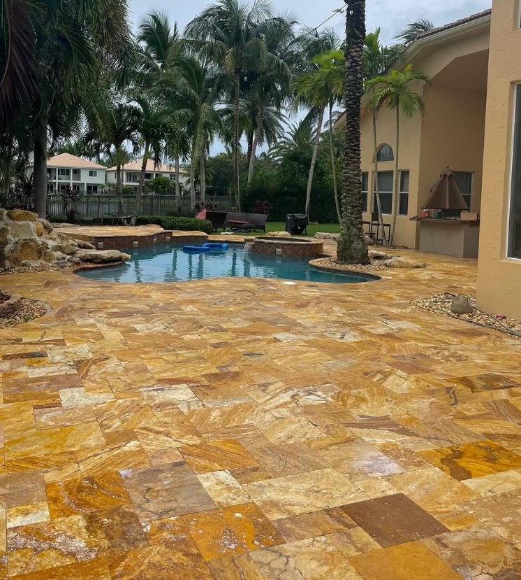 The same pool deck after cleaning and sealing, with the stone color brought back