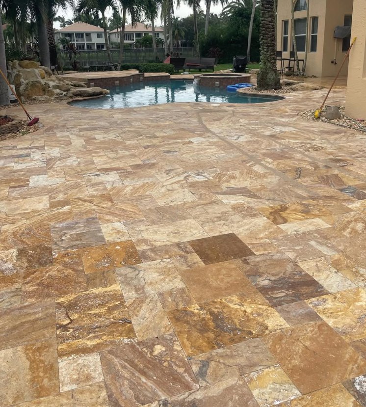 Gold travertine pool deck greyed by weathering and organic staining before cleaning