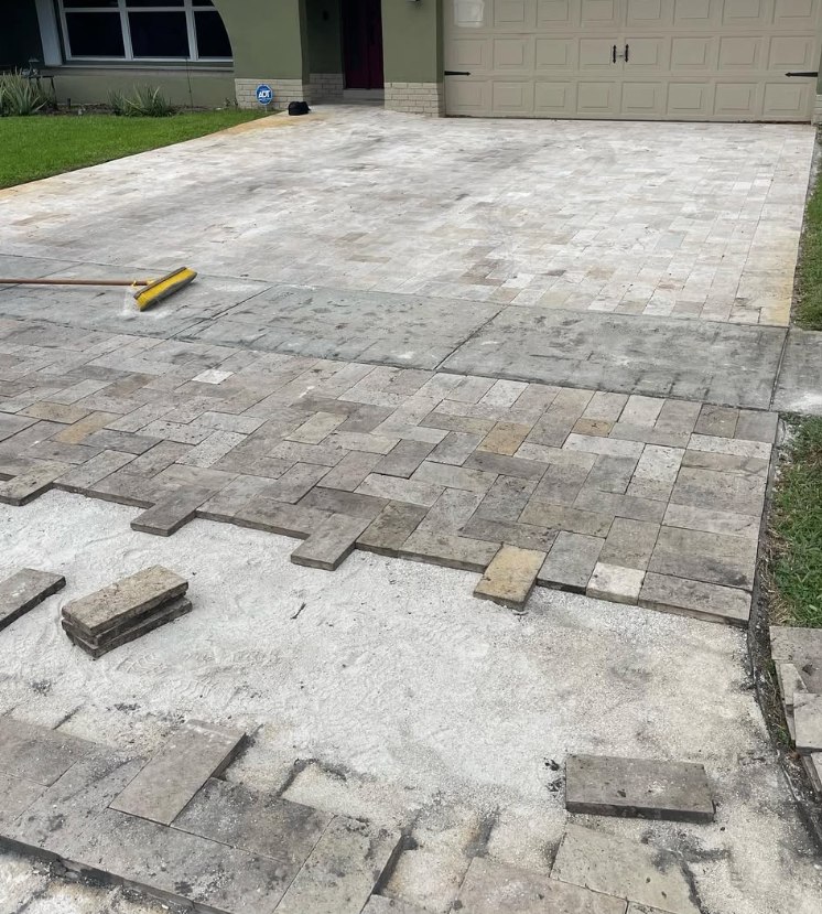 Paver driveway restoration in progress, with new pavers being laid over the old concrete